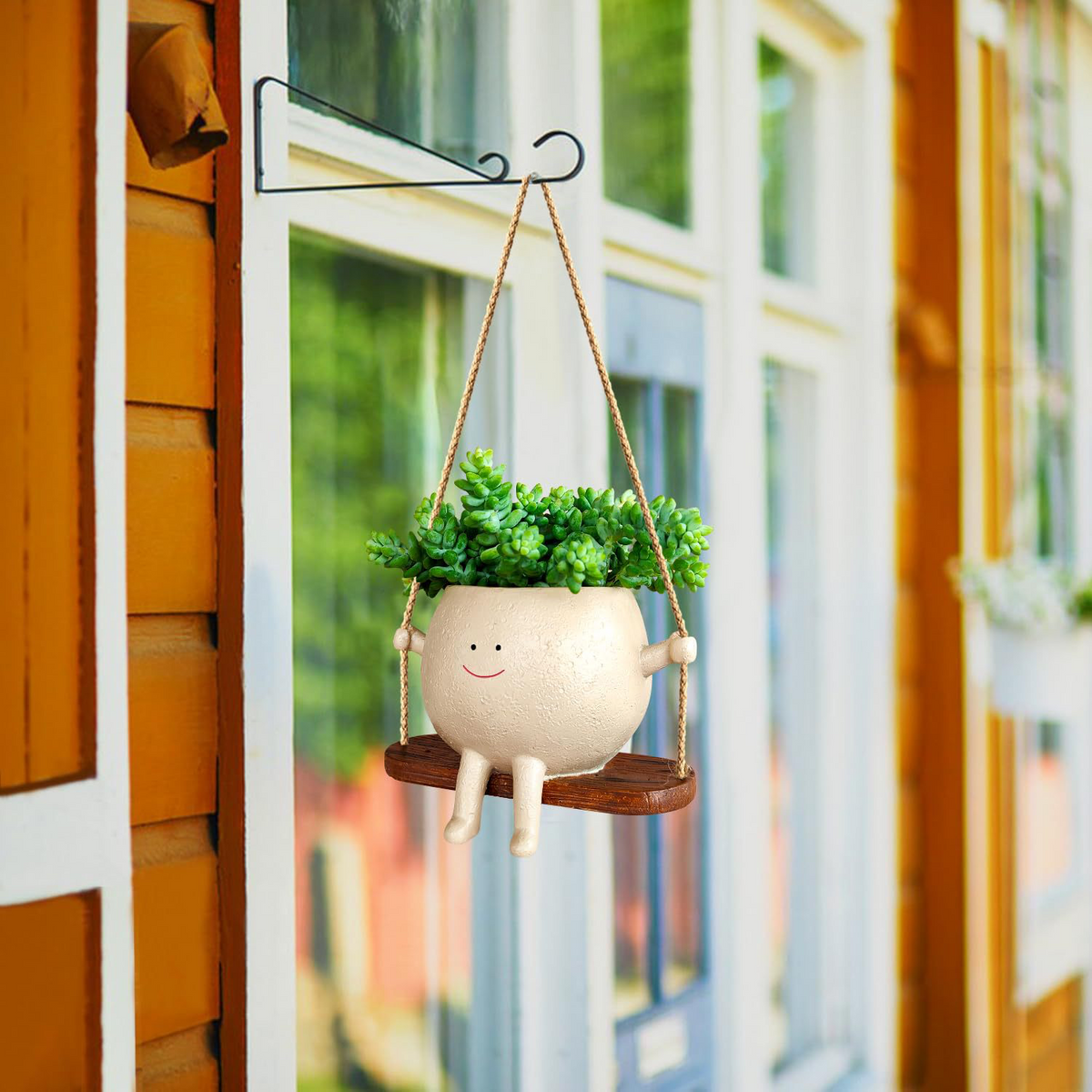 Miniko Swing Time planter with succulents hanging from a hook by a window